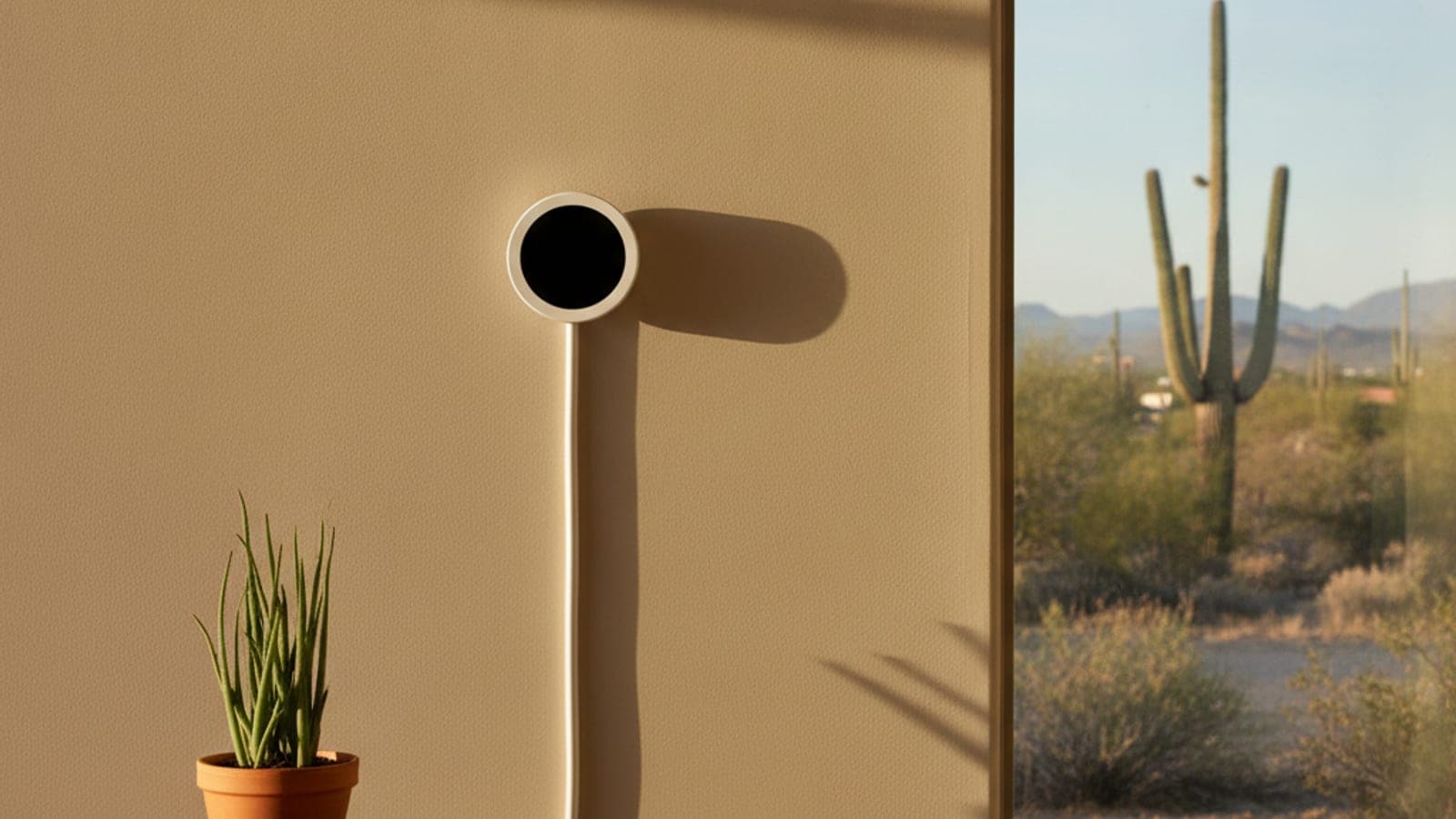 Termostato inteligente en una pared de yeso en una casa de Tucson con luz cálida de tarde del desierto